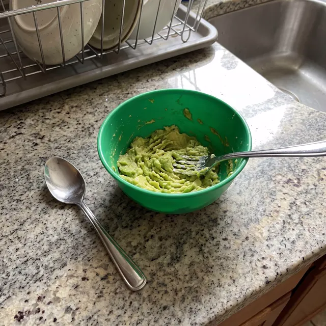 Aguacate pisado en un bol verde